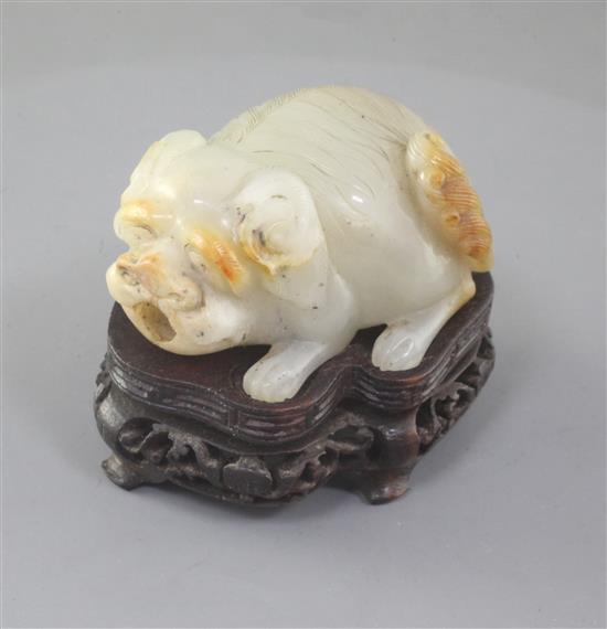 An unusual Chinese pale celadon and russet skin jade lion-dog snuff bottle, 19th century, length 5cm excl. wood stand